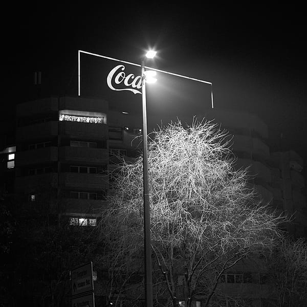 Urban Nocturne - This monochromatic study captures the stark, high-contrast solitude of a city night, where artificial light transforms ordinary elements into dramatic silhouettes