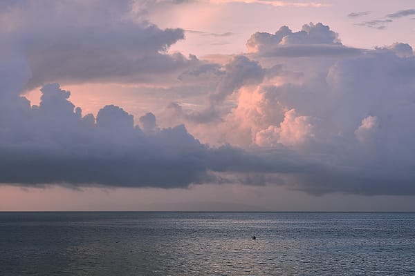 Twilight Over Still Waters - A serene expanse of water meets a dramatic, cloud-filled sky painted in the soft hues of fading daylight