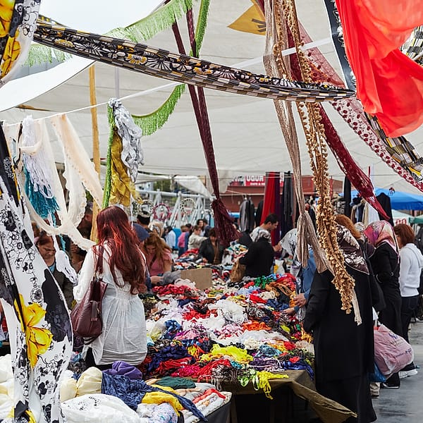 The Fabric Canopy - A vibrant tapestry of commerce and color unfolds beneath a sheltering roof of hanging fabrics