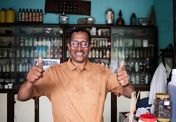 The Merchant's Double Approval - A sense of genuine hospitality and pride radiates from this portrait set within a bustling, cluttered workspace