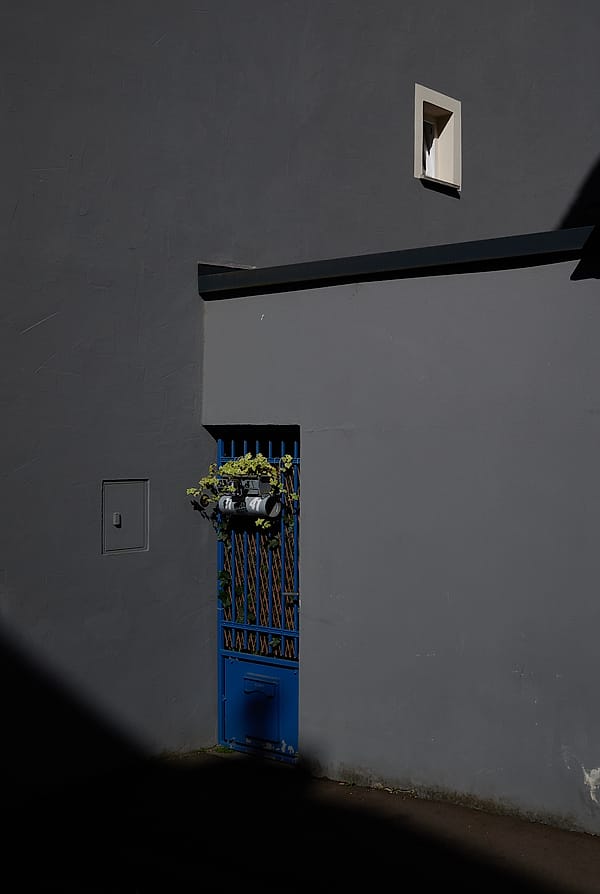 Blue Door Geometry - This piece captures a moment of architectural stillness, defined by the sharp contrast between deep shadow and a singular burst of color
