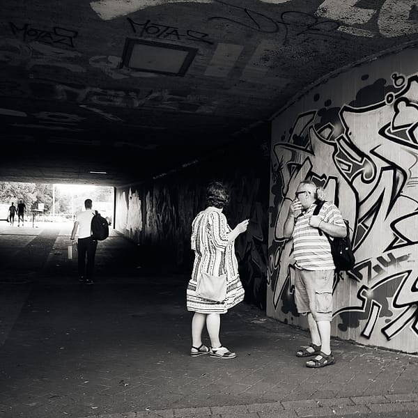 Urban Passage - A stark monochromatic study of urban transit captures the fleeting nature of public interaction within a gritty subterranean space